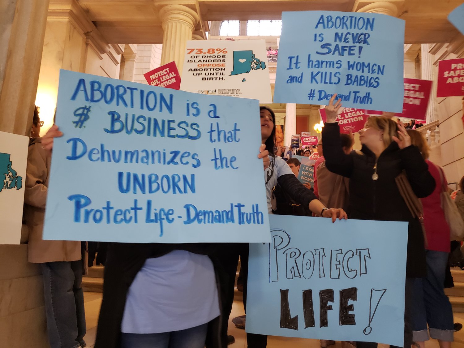 Pro-life activists hold signs in opposition to a Senate bill that would have expanded legal abortion in Rhode Island.